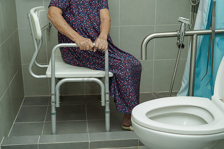 亚洲老年老妇患者在浴室使用马桶支撑栏、扶手安全扶手、护理医院的安全。