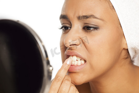 年轻的黑皮肤女人用手指剔牙的肖像