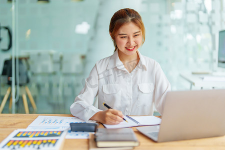 数据分析、计划、营销、会计、审计、亚洲女商人的肖像规划营销使用统计数据表和计算机在会议上展示营销计划项目。