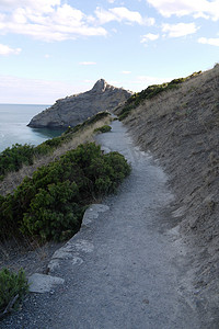 导航导航条摄影照片_岩石和无边黑海背景上的一条小路