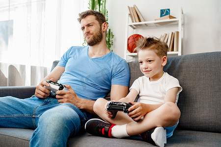 父亲和他的小儿子在家一起玩电子游戏