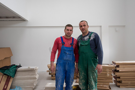建筑工人的工具摄影照片_公寓里穿着脏制服的工人和建筑工人的肖像