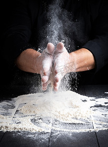 面粉飞溅摄影照片_男人的手和白小麦粉的飞溅
