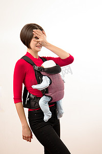 不合摄影照片_Babywearing 混淆了年轻妈妈和不合格背带中的婴儿。