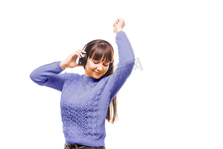 冬天的音乐背景摄影照片_一位身穿紫罗兰色毛衣的黑发女性正在戴着耳机听音乐。