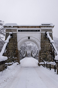 老石摄影照片_挪威雪中的老石吊桥