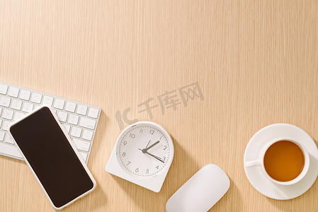带键盘、鼠标、时钟、手机、笔和咖啡的现代白色办公桌。顶视图与复制粘贴。