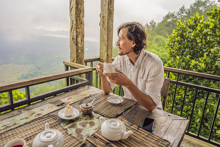 森林咖啡摄影照片_山中咖啡馆里喝茶的男人
