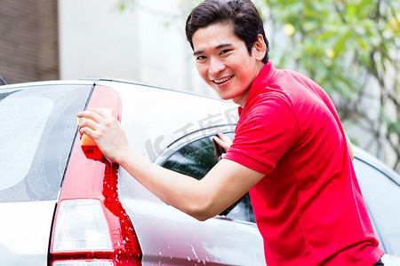 亚洲人用海绵清洁和洗车