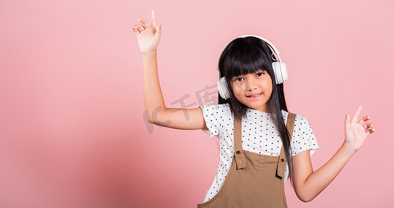 亚洲小孩 10 岁微笑着听音乐戴着无线耳机跳舞