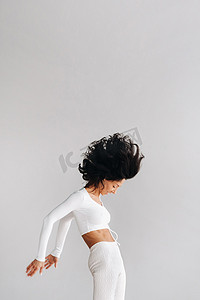 运动馆背景摄影照片_一位身穿白色运动服的女士正在瑜伽馆进行动态卡利冥想