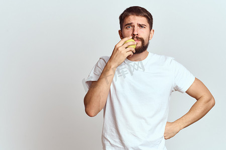 精力充沛的男人，带着苹果健康维生素饮食和生活方式的白色 T 恤裁剪视图