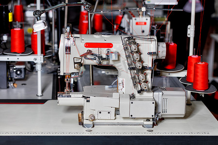 现代缝纫设备，多功能缝纫机，带红线特写线轴。