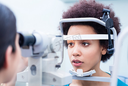 配镜师用折射计测量女性眼睛