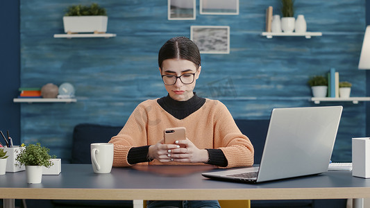 坐在办公桌前使用智能手机浏览互联网的人