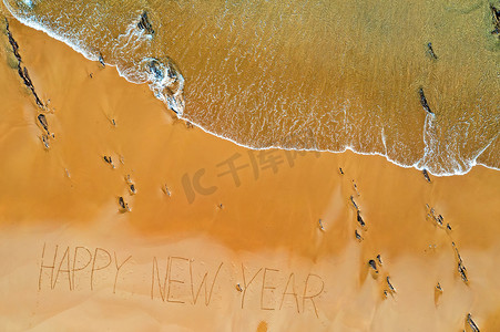 海浪的空中顶部拍摄和手写的新年快乐
