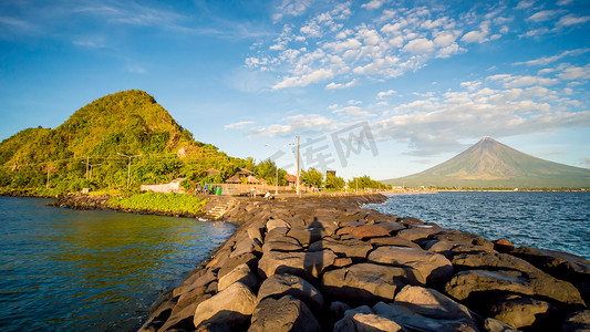 菲律宾吕宋岛黎牙实比市 - 随着日常生活的进行，马荣火山笼罩着这座城市。