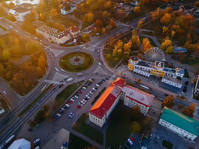 秋日公路摄影照片_秋日阳光明媚的欧洲小城市环岛公路与圆形汽车的鸟瞰图