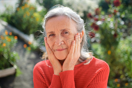 一位头发灰白的成熟女性在阳光明媚的日子里在户外度过时光，退休快乐