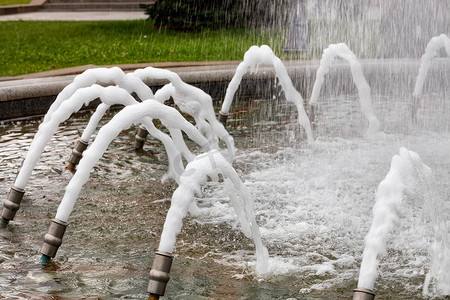 城市喷泉的金属喷嘴喷出密集的泡沫水流。