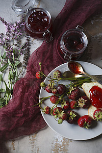 夏季早餐概念包括草莓果酱、面包和新鲜收获的浆果。
