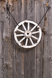 谷仓墙上垂悬的一个旧木车轮