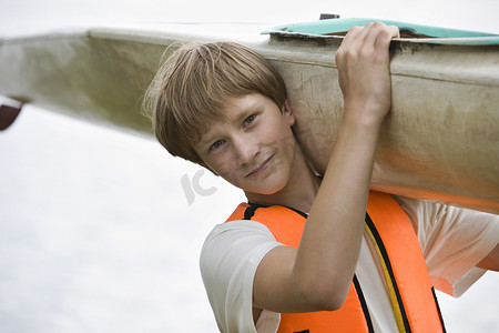 携带皮划艇的十几岁男孩