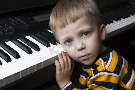 钢琴作曲家摄影照片_梦见小男孩坐在钢琴前