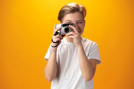 照片墙带照片摄影照片_黄色背景中带旧相机的小男孩