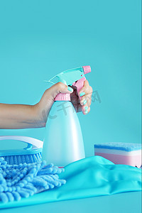 女人手拿着清洁喷雾蓝色塑料瓶洗涤剂