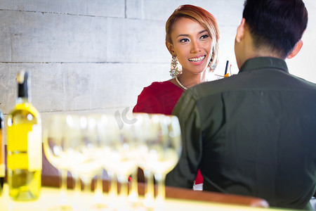 高档眼镜摄影照片_亚洲夫妇在高档酒吧喝白葡萄酒