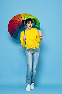 带着彩虹色雨伞摆出街头风格的快乐女人