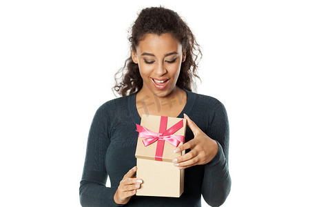 快乐的非洲女人打开一个装有礼物的盒子