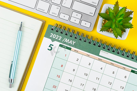 5月份摄影照片_2022 年 5 月台历和日记，带键盘电脑。