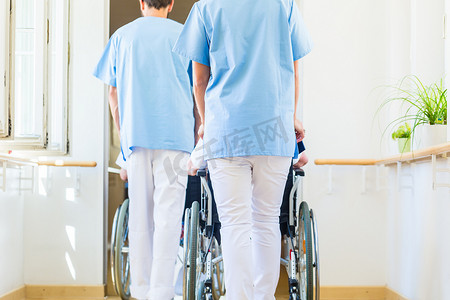 护士推着轮椅的老人穿过疗养院