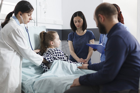 儿科医生用听诊器咨询生病的小女孩，而担心的父母在她旁边等着。