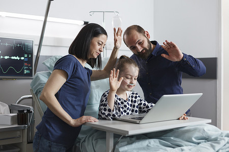 幸福的家庭在病房里通过视频通话技术与亲戚交谈。