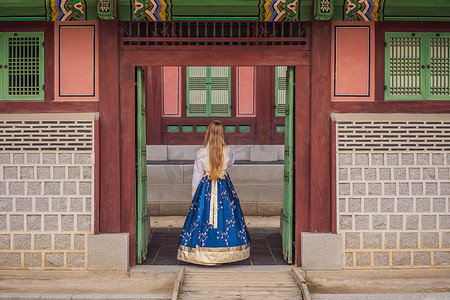 韩服女摄影照片_穿着韩服的年轻白人女游客在韩国宫殿。