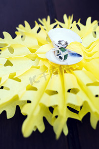 星环摄影照片_结婚戒指放在黄色星背景上的壳里。