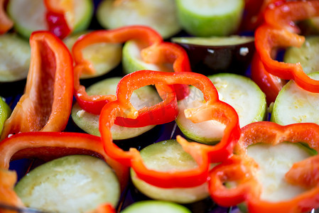 素食烧烤摄影照片_新鲜辣椒和茄子在烧烤前特写