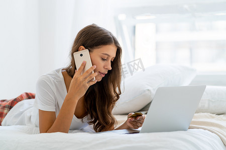 年轻女子在网上购物，用手机说话，银行打来的安全电话。