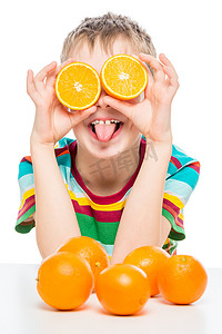 滑稽摄影照片_白色背景上一个拿着橙子的滑稽男孩的垂直肖像
