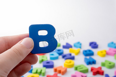 彩色字母块旁边手中的字母 B