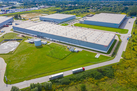 仓库鸟瞰摄影照片_卡车开往物流中心的仓库鸟瞰图.