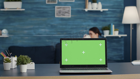 显示屏模板摄影照片_桌面上带有绿色屏幕背景的笔记本电脑显示屏