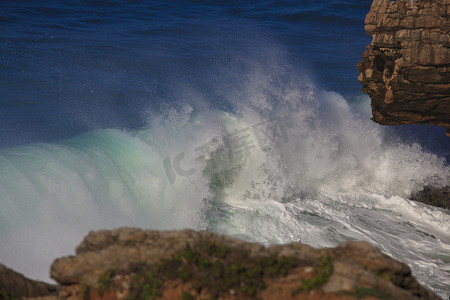 冲击海浪摄影照片_海浪冲击近海岩石