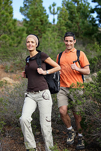 年轻夫妇徒步穿过树林