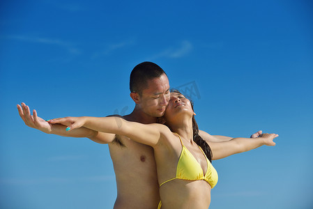 约会夏天摄影照片_快乐的年轻夫妇在海滩上享受夏天
