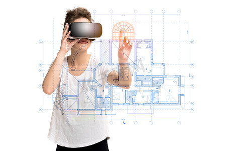 年轻女孩使用 VR 耳机眼镜获得经验，创建房屋项目，处于虚拟现实中