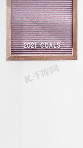 粉色信纸摄影照片_浅粉色字母板，上面写着 2021 年目标。